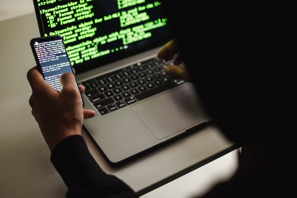 5926389-5926389-1 Crop unrecognizable developer using laptop and smartphone